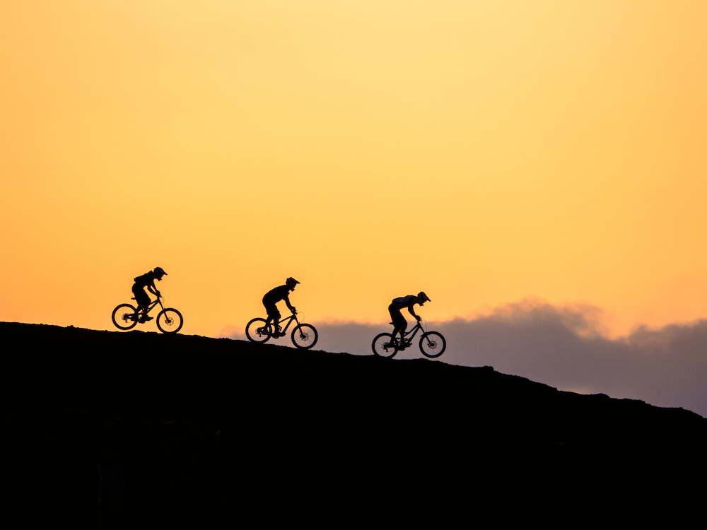 Mountainbiker fahren im Sonnenuntergang
