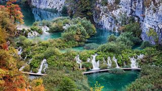 Blick von oben auf die Plitvicer Seen mit Wasserfällen und grüner Landschaft: Geheimtipp für Deinen Kroatien Roadtrip mit dem Camper