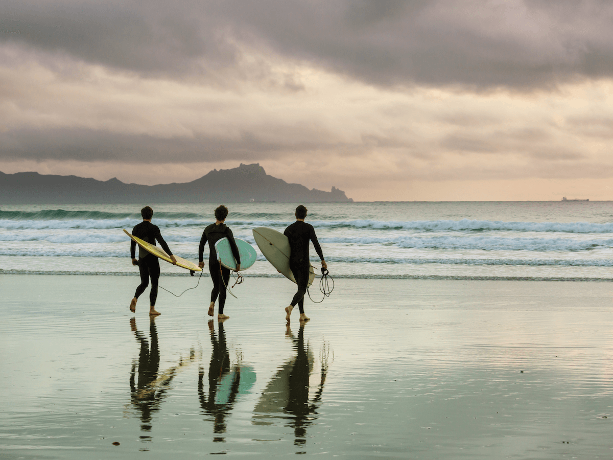 3 Surfer auf dem Weg zum Meer