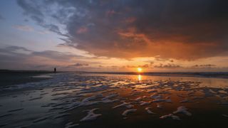 Sonnenuntergang mit wunderschönen Farben am Meer beim Camping Trip in Holland am Meer