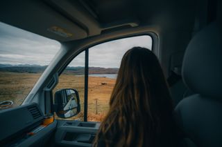 Eine Frau blickt aus einem Autofenster auf die schottische Landschaft.