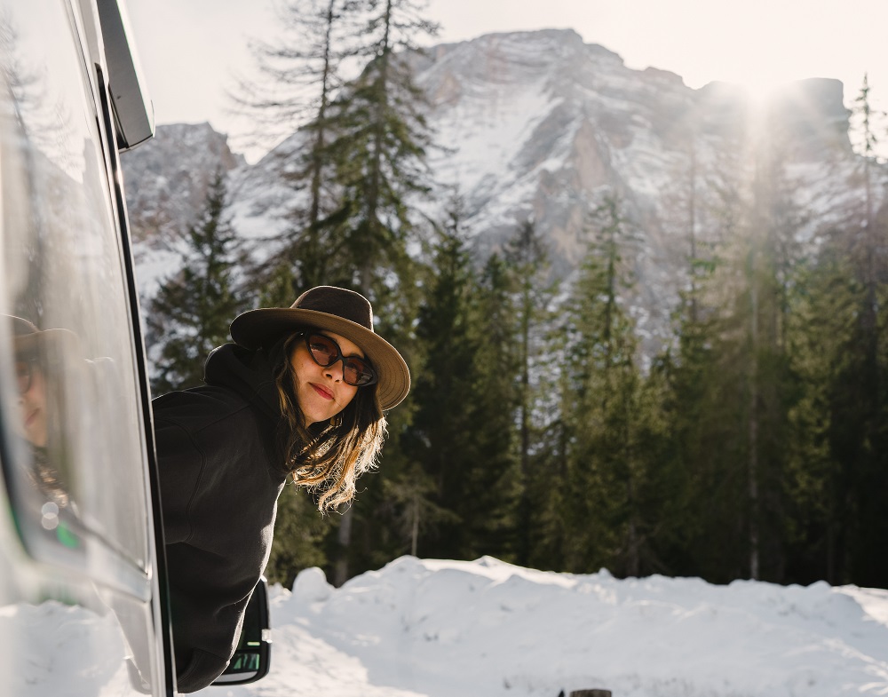 Frau schaut aus dem VW Grand California im Winter