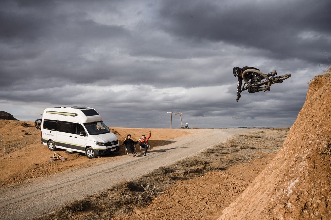 BMX Profis machen Stunts mit VW Grand California im Hintergrun