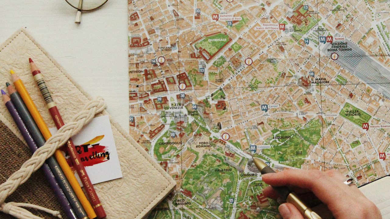 Eine Citymap mit einer Hand und vielen Stiften