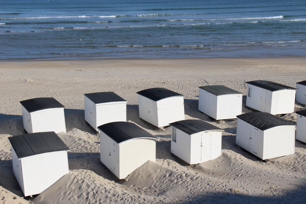 Weiße Strandhütten am Strand von Dänemark