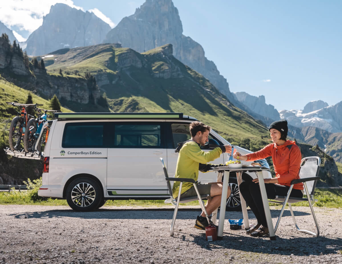 VW California Ocean couple eating in the mountains