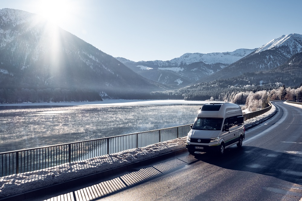 VW Grand California fährt auf verschneiter Bergstraße
