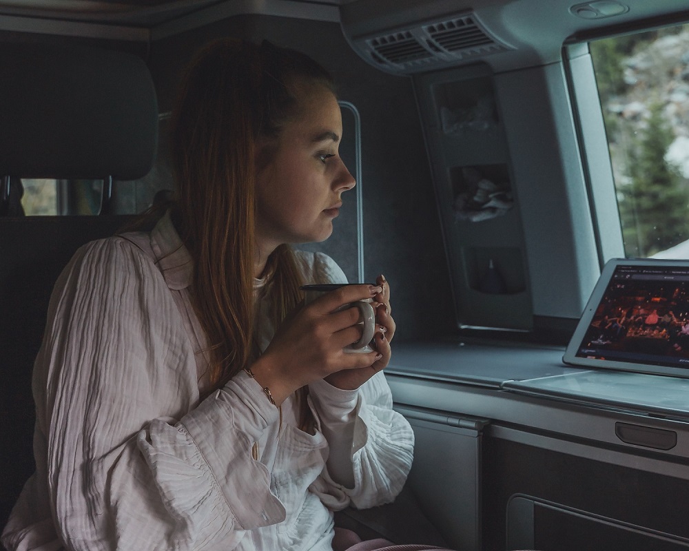 Frau im VW Grand California 600 schaut auf ihr iPad