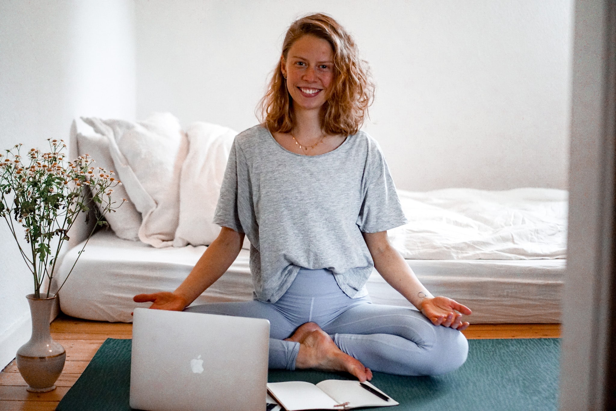 Frau macht Yoga vor einem Laptop